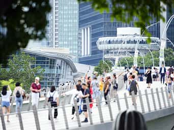Defocused crowd of local people and tourists walking on a bridge in Singapore.